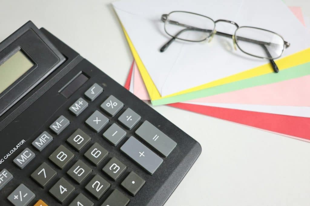 Calculator and glasses on colorful papers